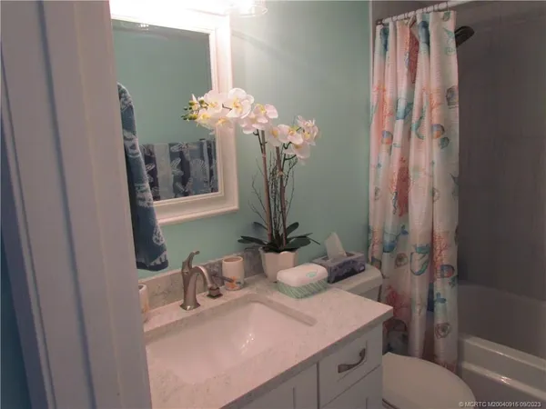 a bathroom with a sink a toilet and shower curtain