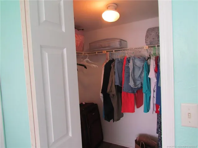 a view of walk in closet with clothes