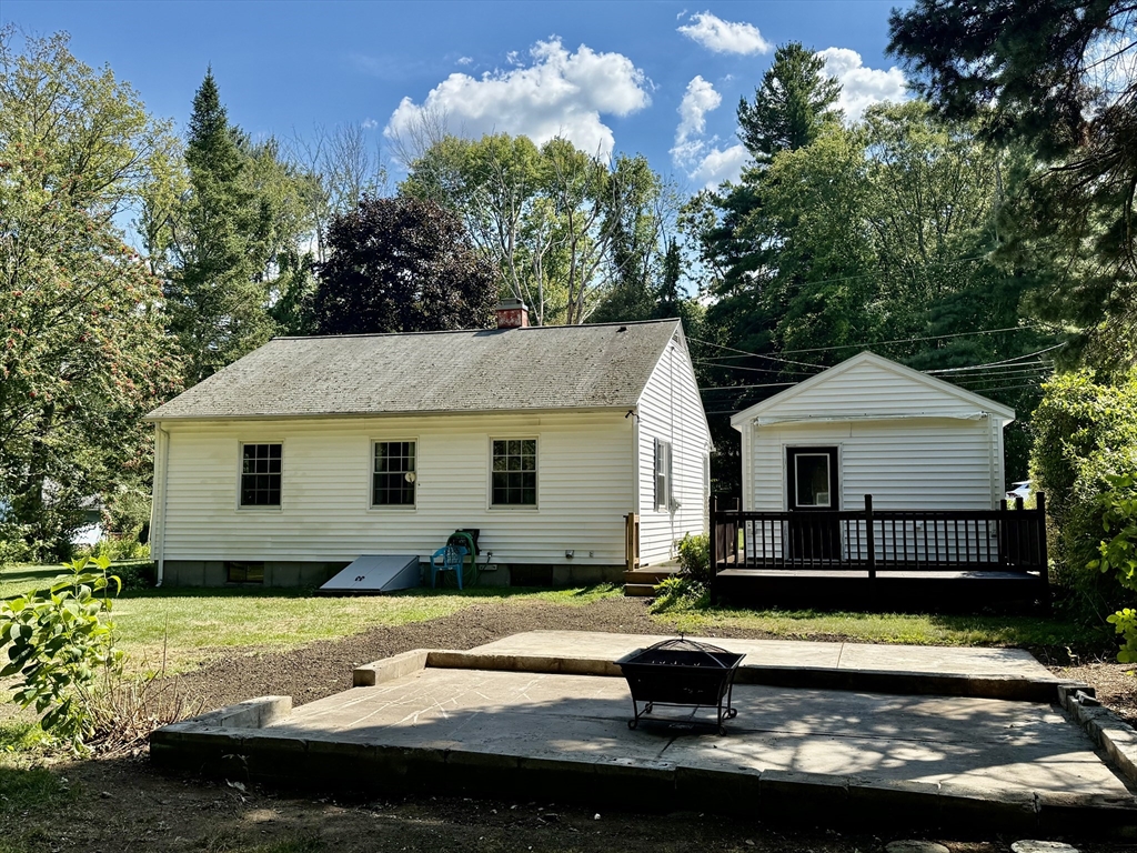 570 Sutton Street Northbridge, MA 01534 - Photo 17 of 20 a view of a white house with a swimming pool and a yard with plants