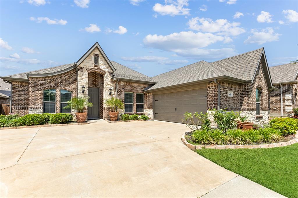 a front view of a house with a yard and potted plants