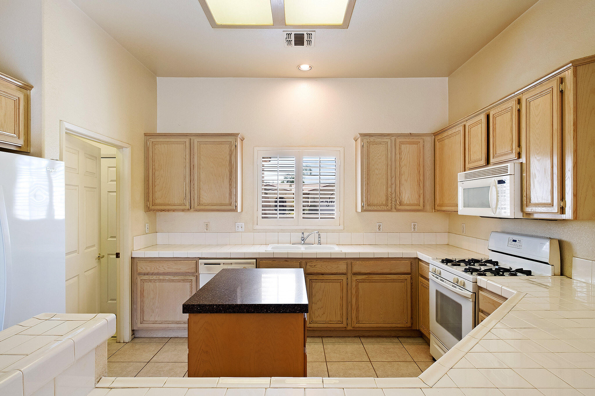 68338 Riviera Road Cathedral City, CA 92234 - Photo 16 of 29 a kitchen with a sink stove and cabinets