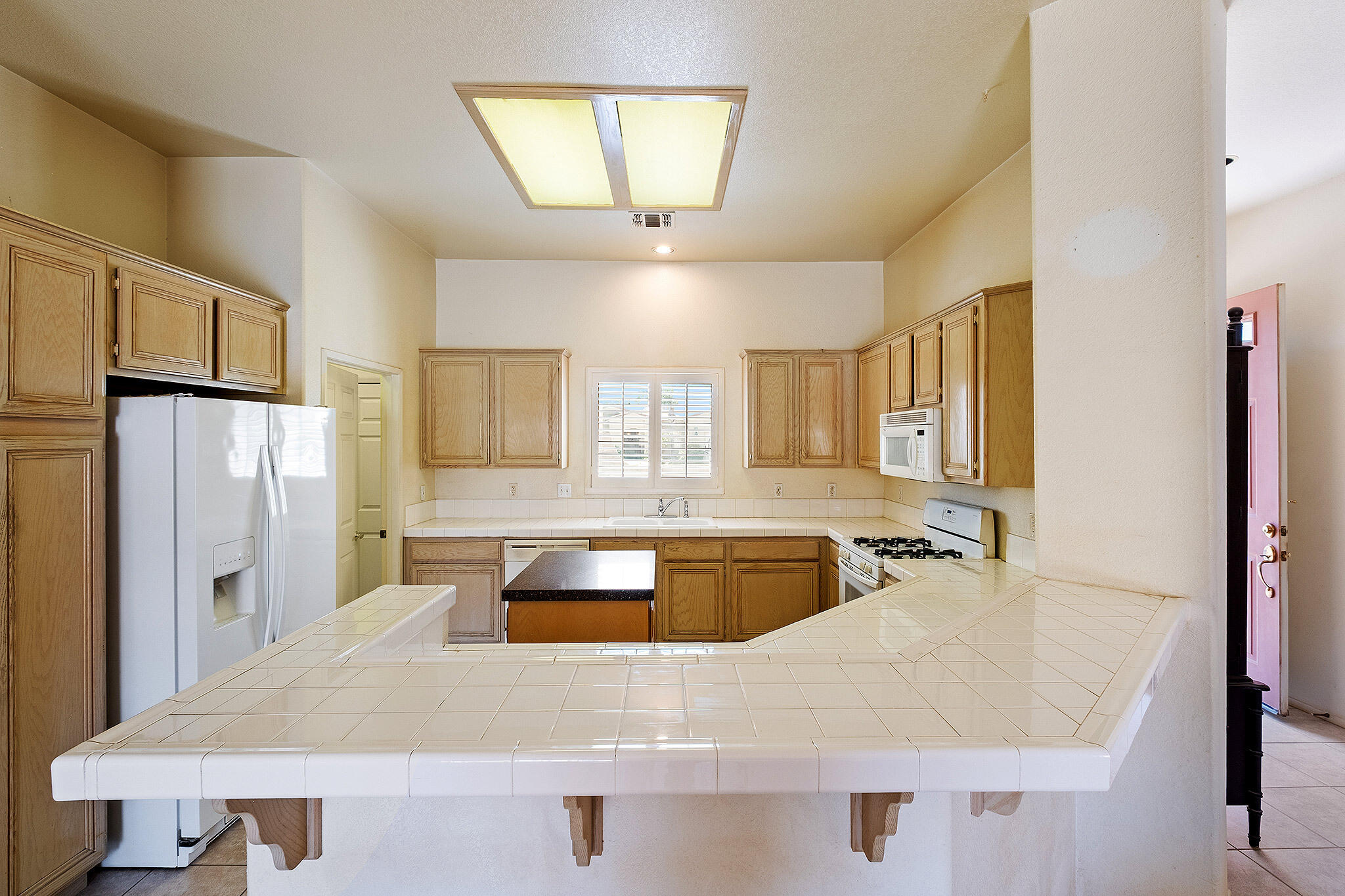 68338 Riviera Road Cathedral City, CA 92234 - Photo 18 of 29 a large kitchen with kitchen island a refrigerator stove and sink