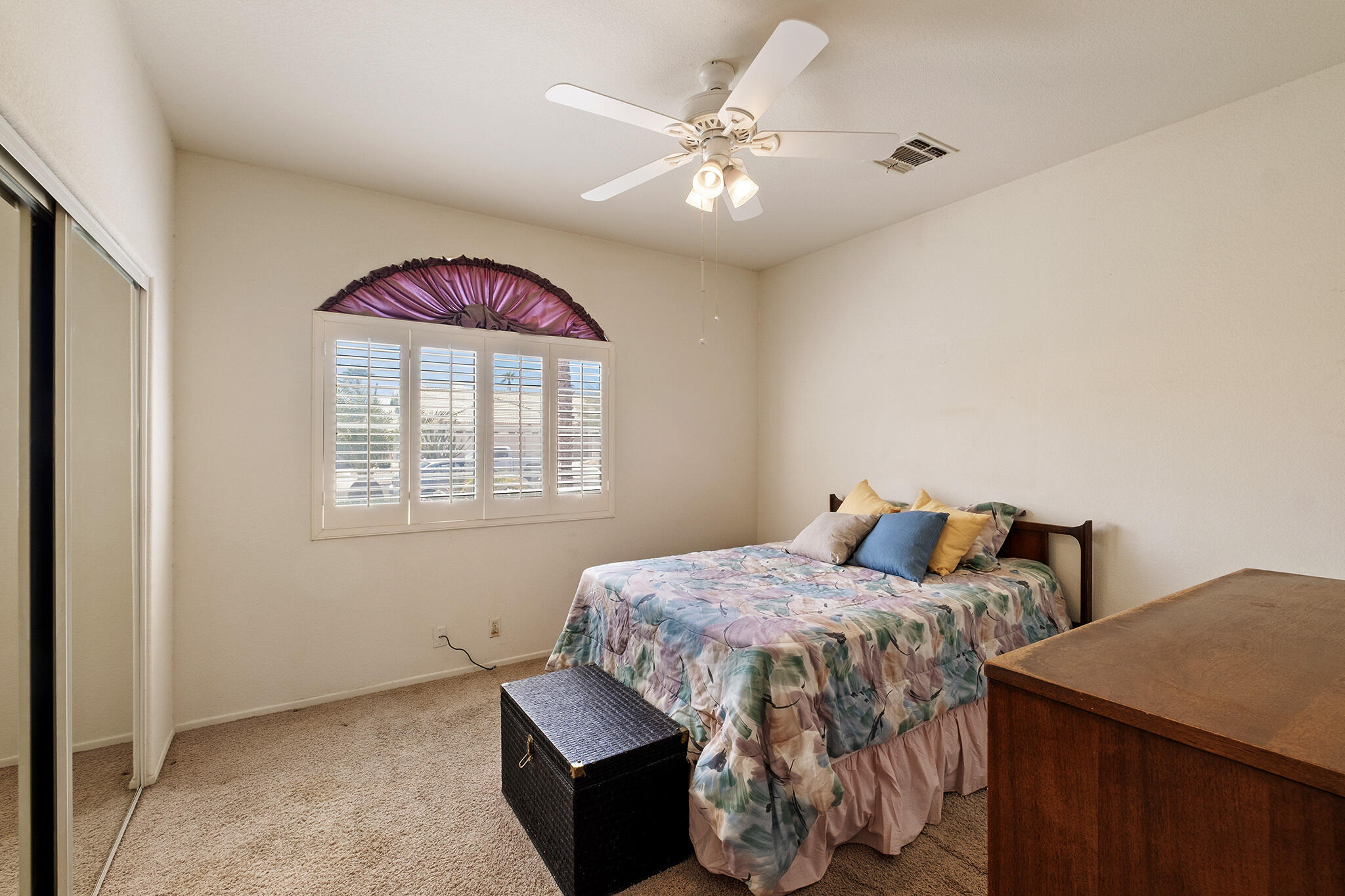 68338 Riviera Road Cathedral City, CA 92234 - Photo 25 of 29 a bedroom with a bed and a chandelier