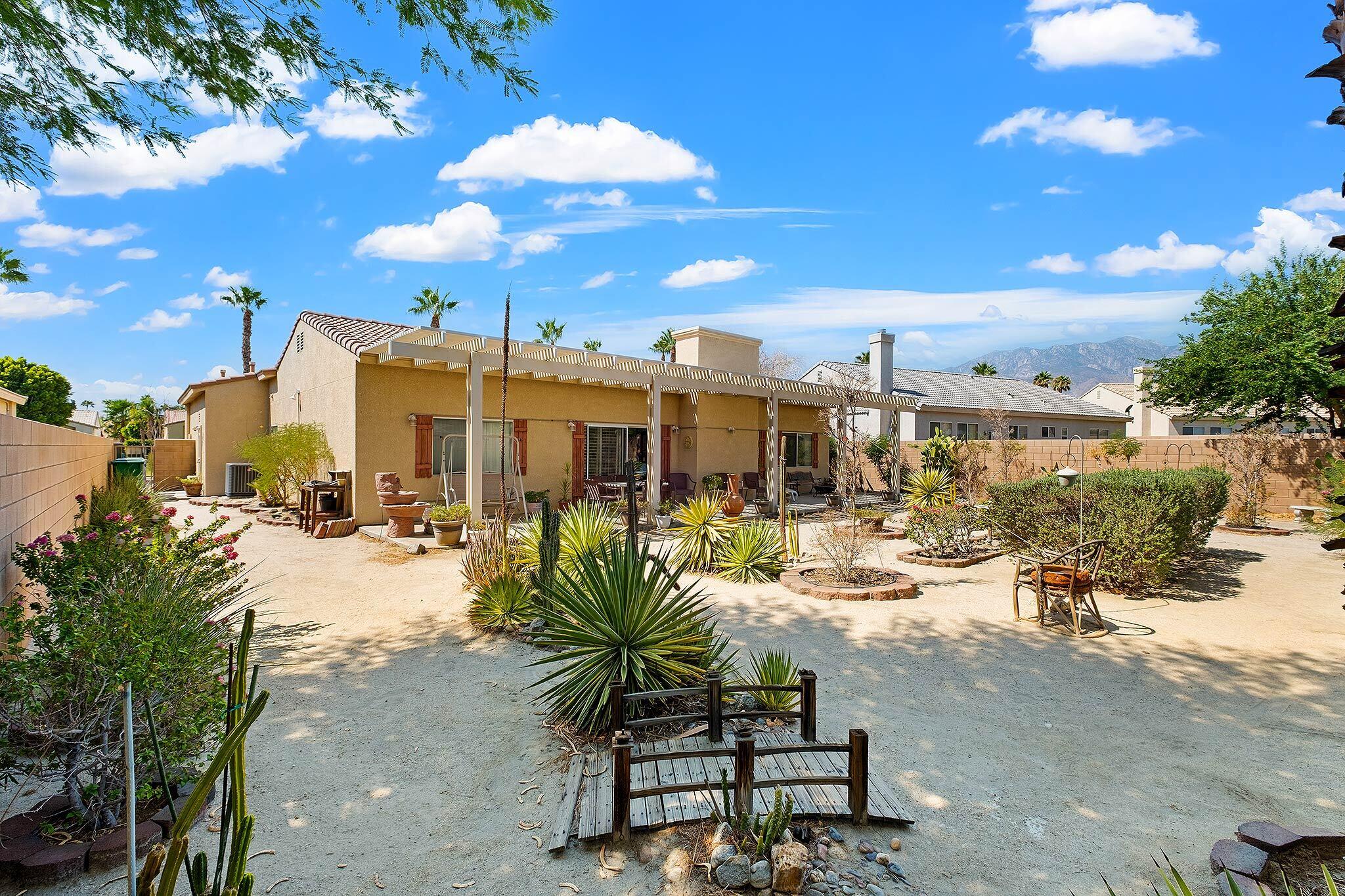 68338 Riviera Road Cathedral City, CA 92234 - Photo 6 of 29 a view of a swimming pool with outdoor seating and a garden