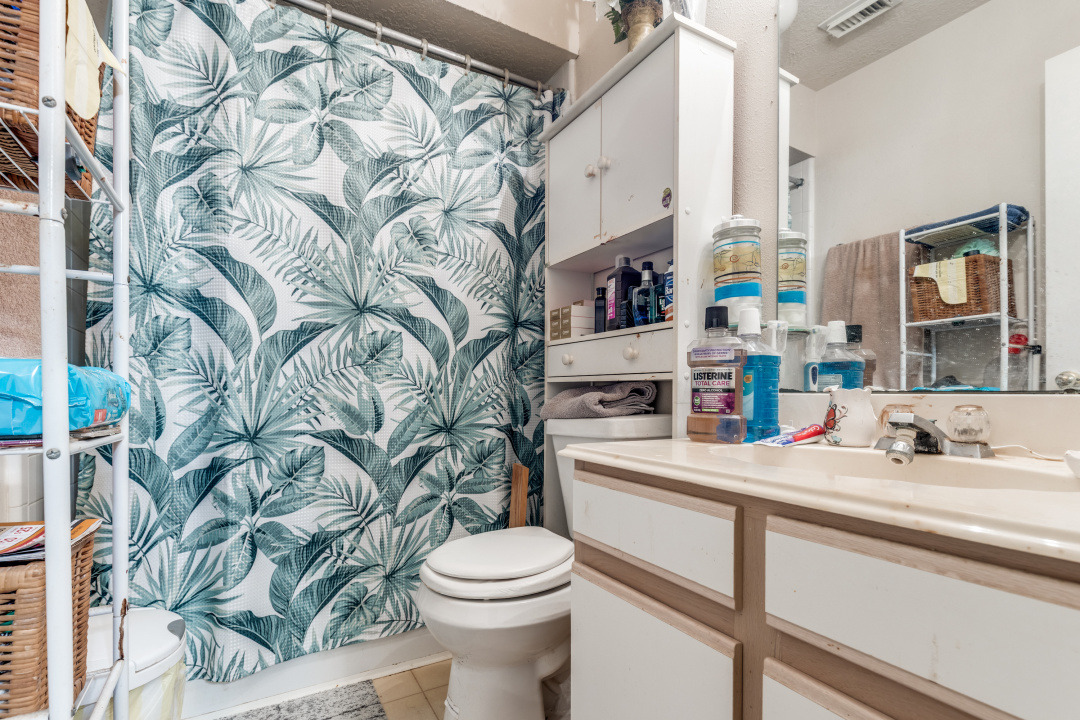 10007 Raymondville Road Houston, TX 77093 - Photo 13 of 19 Bathroom featuring a shower with curtain, vanity, and light tile patterned flooring