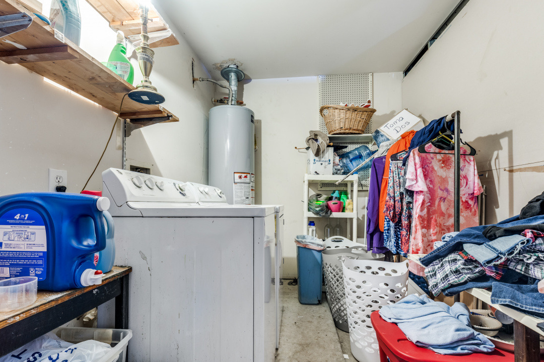 10007 Raymondville Road Houston, TX 77093 - Photo 15 of 19 Laundry room with unfinished concrete floors, gas water heater, and independent washer and dryer
