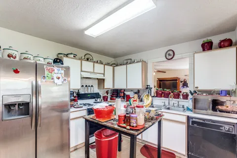 a kitchen with a refrigerator a stove and a dining table