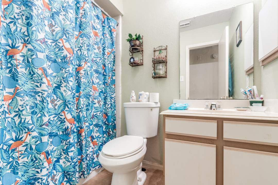 10007 Raymondville Road Houston, TX 77093 - Photo 10 of 19 Bathroom with vanity, a shower with shower curtain, and a textured wall