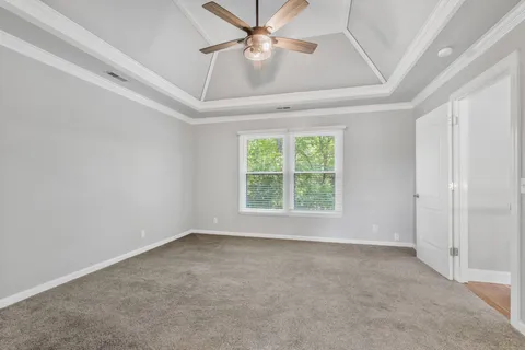 an empty room with a window and a fan