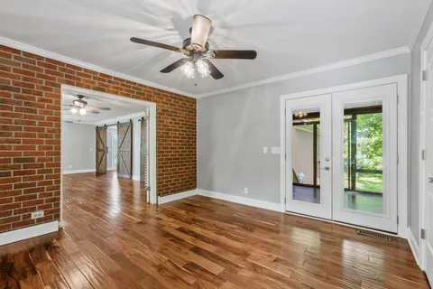 a view of a livingroom with wooden floor and a ceiling fan