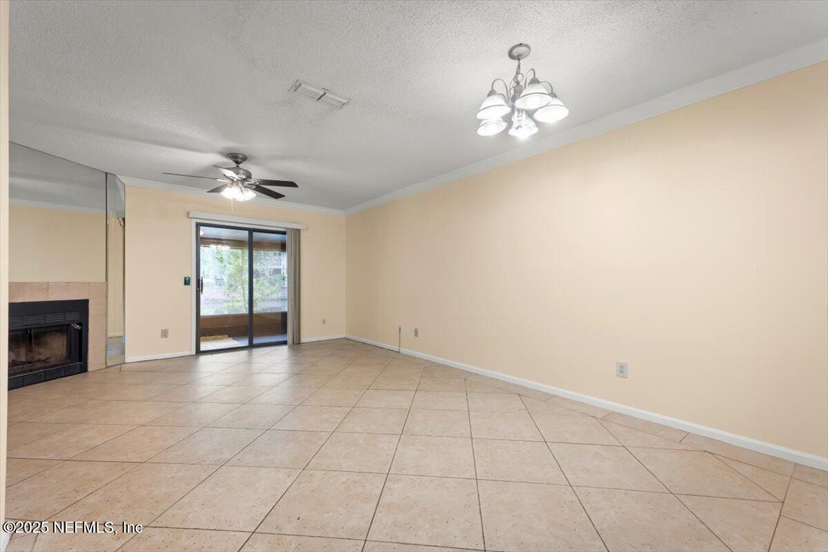 3801 Crown Point Road, Unit 3073 Jacksonville, FL 32257 - Photo 12 of 26 a view of an empty room with a chandelier fan and fireplace