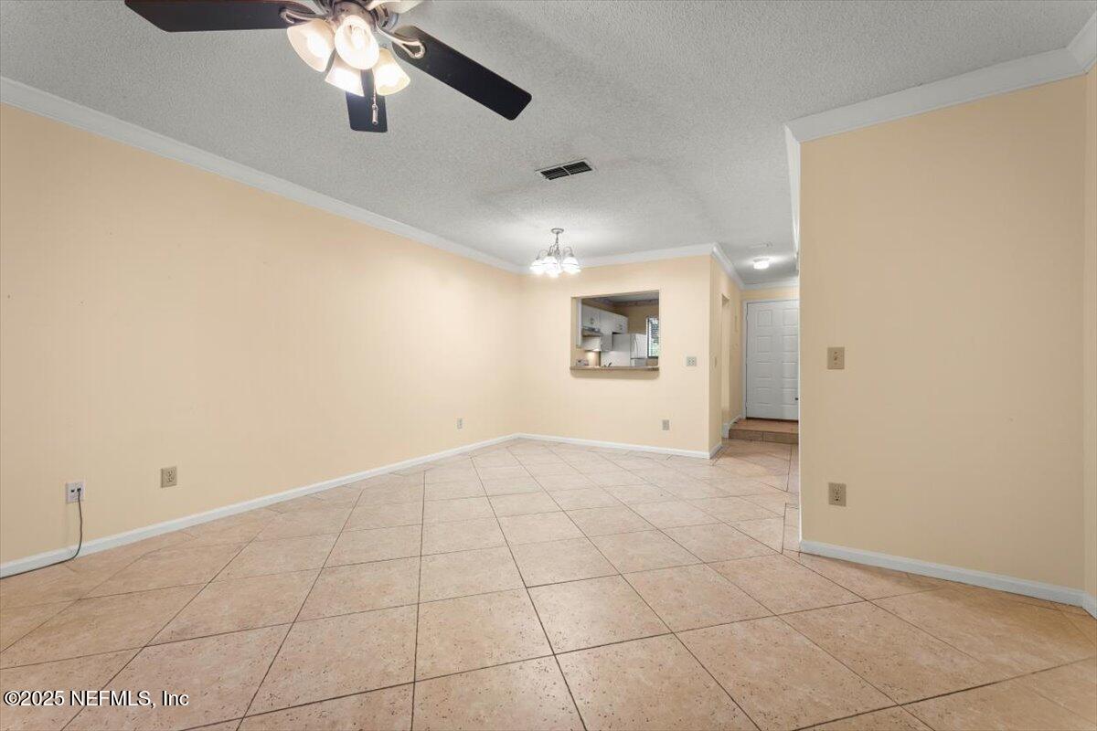 3801 Crown Point Road, Unit 3073 Jacksonville, FL 32257 - Photo 17 of 26 an empty room with a chandelier fan and windows
