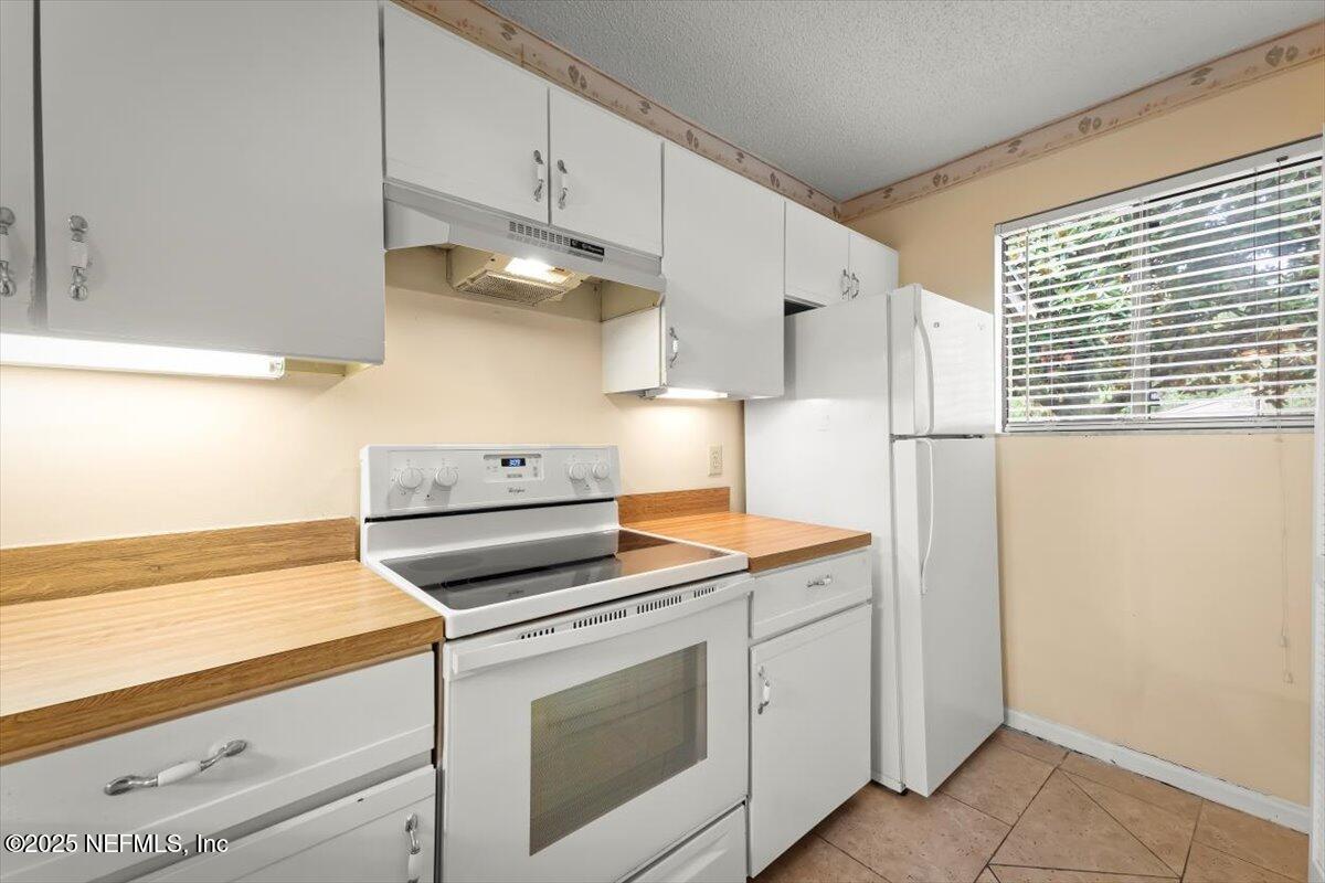 3801 Crown Point Road, Unit 3073 Jacksonville, FL 32257 - Photo 9 of 26 a kitchen with white cabinets and white appliances