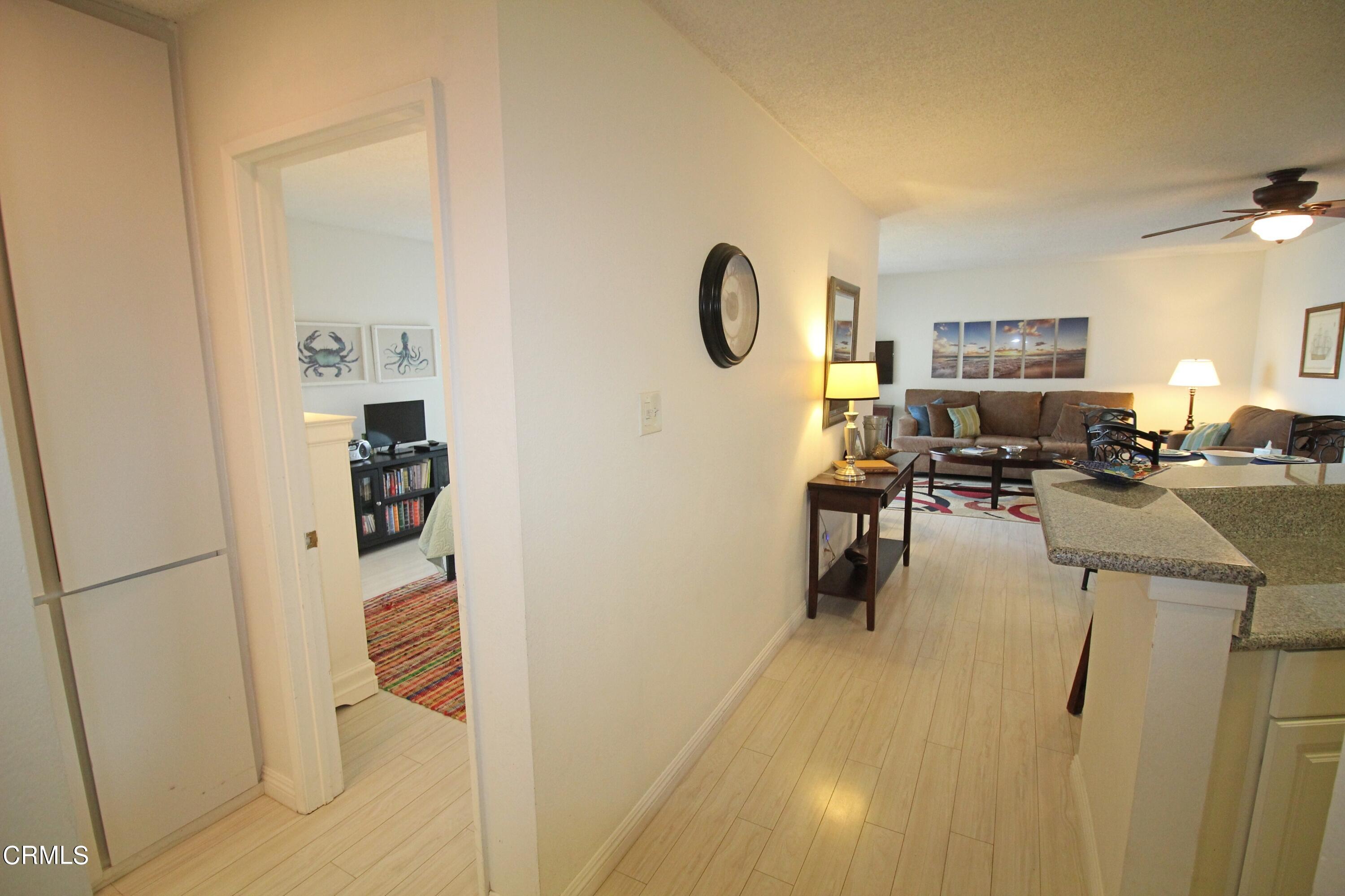 a living room with furniture a dining table and a refrigerator