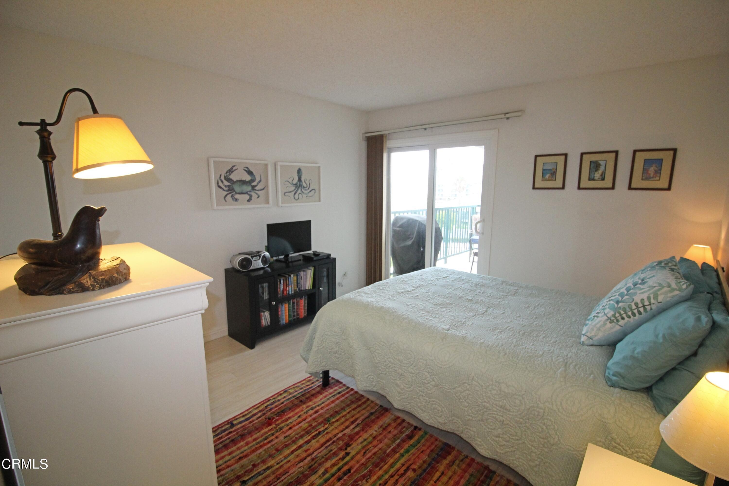 3101 Peninsula Road, Unit 312 Oxnard, CA 93035 - Photo 13 of 26 a bedroom with a bed and a mirror on dresser