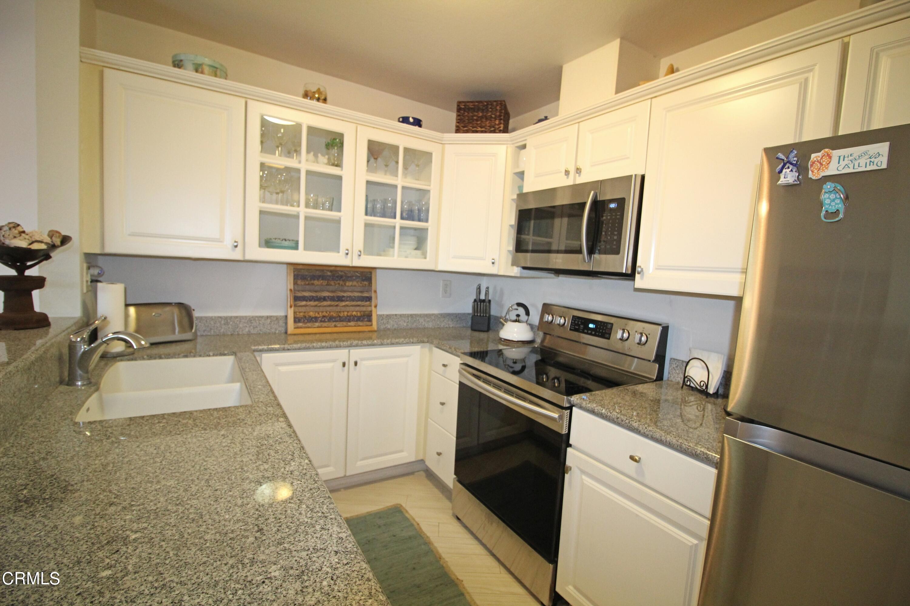 3101 Peninsula Road, Unit 312 Oxnard, CA 93035 - Photo 4 of 26 a kitchen with stainless steel appliances granite countertop a stove and a sink
