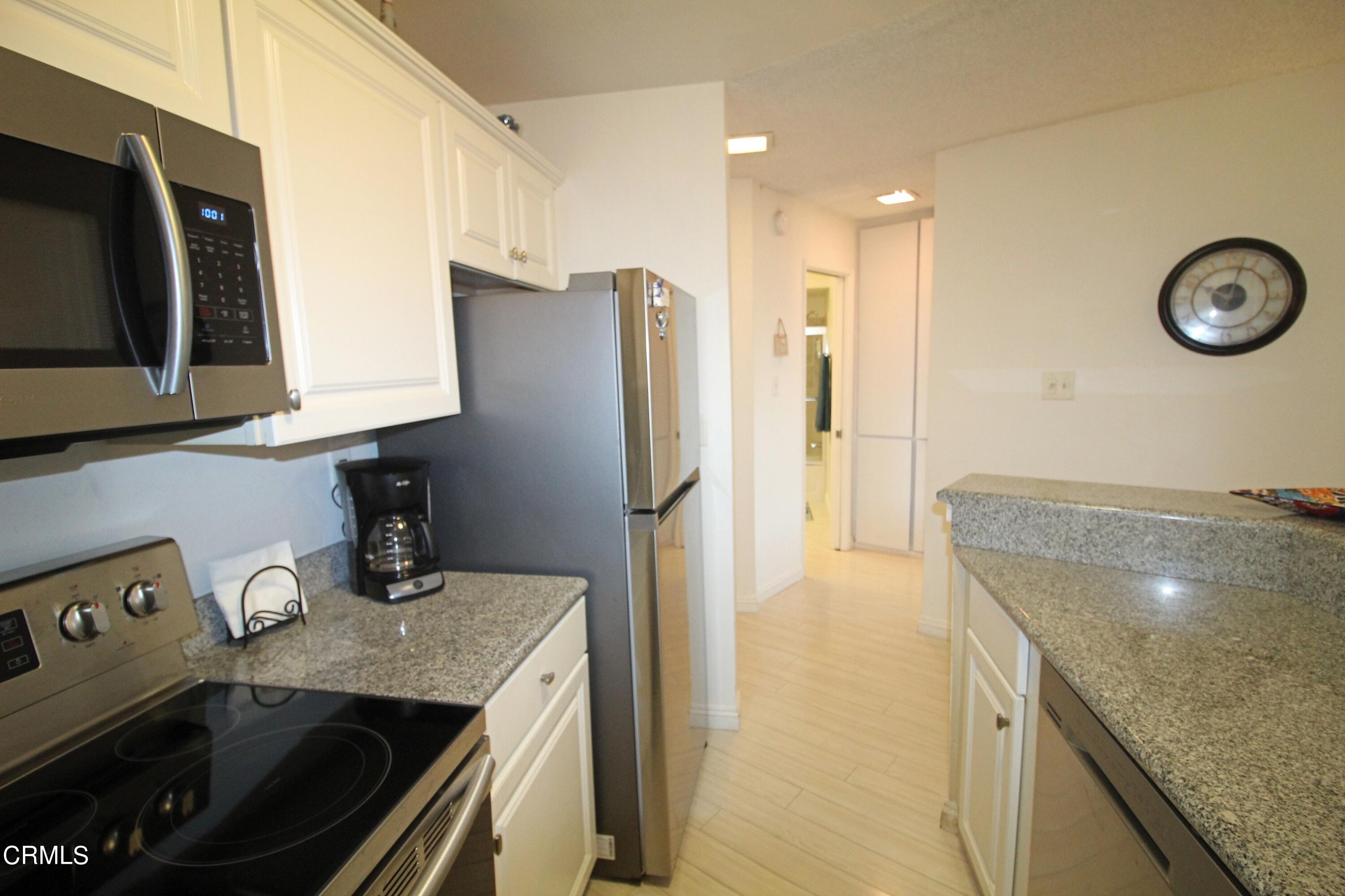 3101 Peninsula Road, Unit 312 Oxnard, CA 93035 - Photo 5 of 26 a kitchen with stainless steel appliances granite countertop a sink a stove and a refrigerator