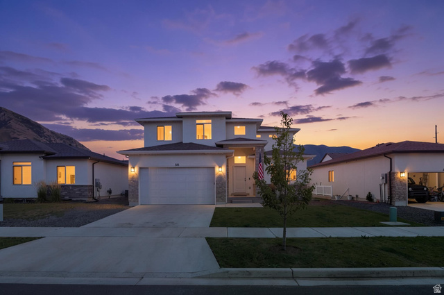 815 West Powderwood Lane Mapleton, UT 84664 - Photo 1 of 34 Modern two-story residence featuring a clean white exterior, stone accents, a two-car garage, and a concrete driveway