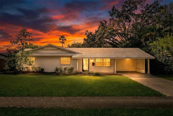 a front view of a house with a garden and yard