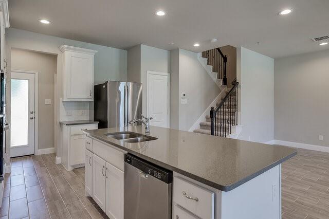 5912 Bursey Road Watauga, TX 76148 - Photo 6 of 23 Kitchen with appliances with stainless steel finishes, a sink, light wood finished floors, an island with sink, and recessed lighting