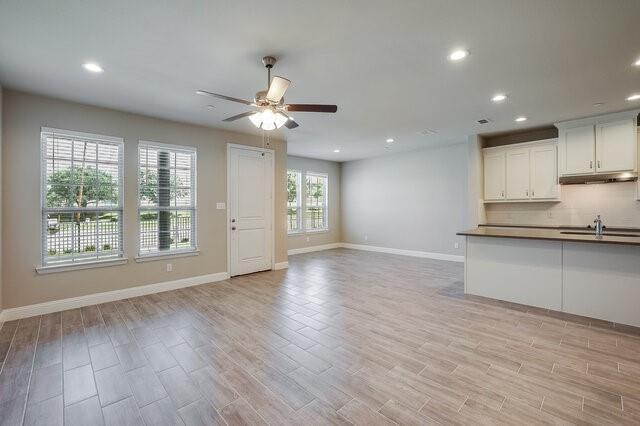 5912 Bursey Road Watauga, TX 76148 - Photo 8 of 23 Unfurnished living room featuring a ceiling fan, recessed lighting, baseboards, a sink, and light wood-style floors
