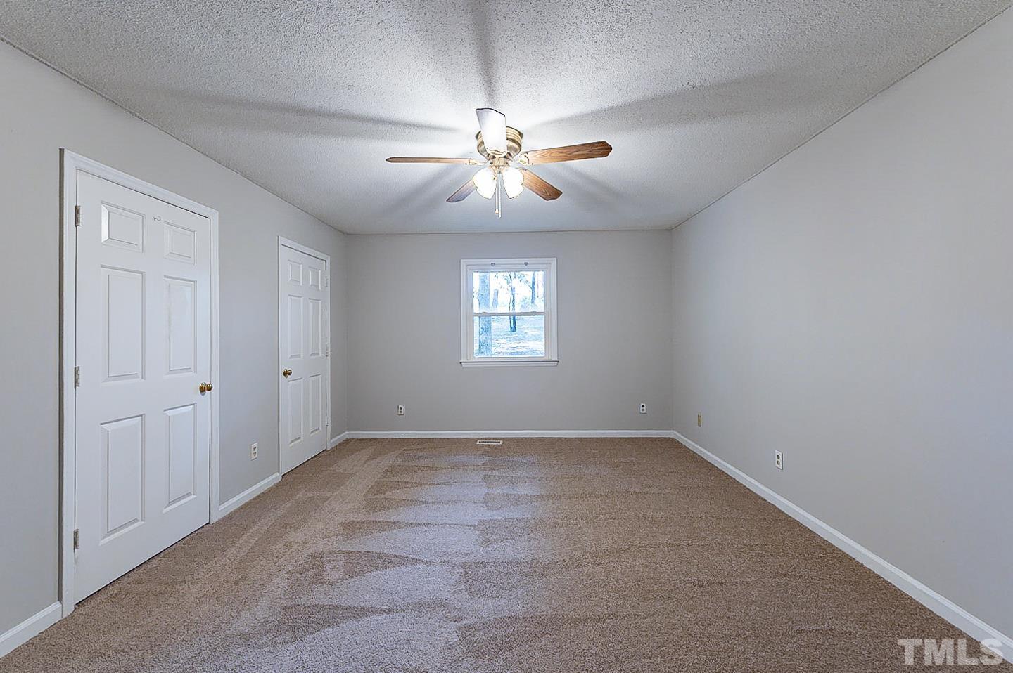 7005 Russell Road Durham, NC 27712 - Photo 12 of 24 an empty room with chandelier fan and windows