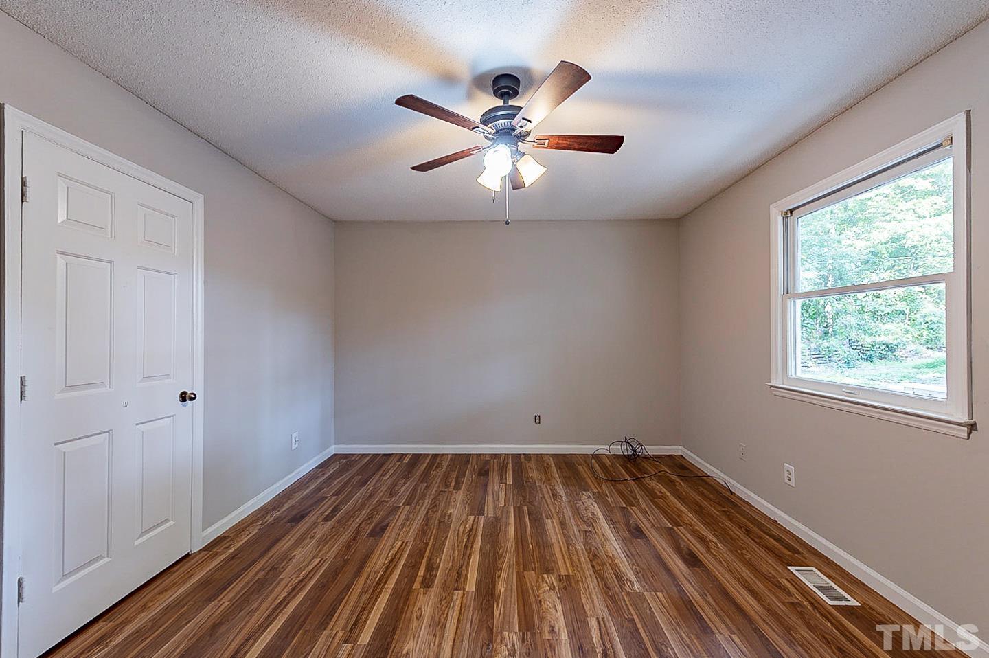7005 Russell Road Durham, NC 27712 - Photo 15 of 24 a view of empty room with wooden floor and fan