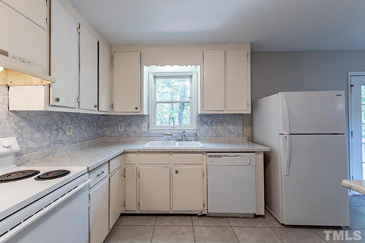 7005 Russell Road Durham, NC 27712 - Photo 8 of 24 a kitchen with a sink a refrigerator and cabinets