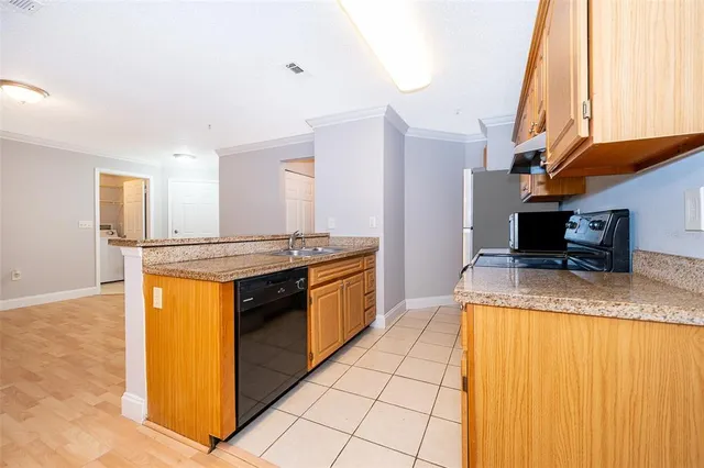 a kitchen with stainless steel appliances granite countertop a sink and a refrigerator