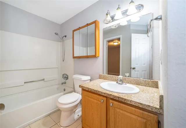 a bathroom with a granite countertop sink toilet a mirror and shower