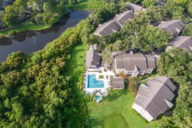 an aerial view of a house with a garden and lake view