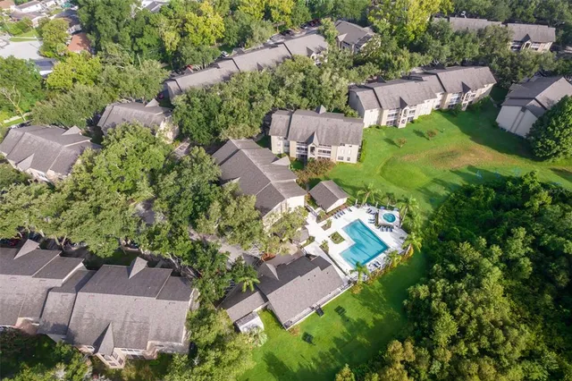 an aerial view of residential house with outdoor space and trees all around
