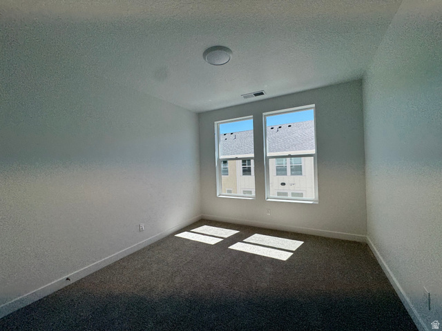 1476 North 1875 West, Unit 152 Layton, UT 84041 - Photo 12 of 20 Room featuring two vertical windows, textured wall finishes, and gray carpeting