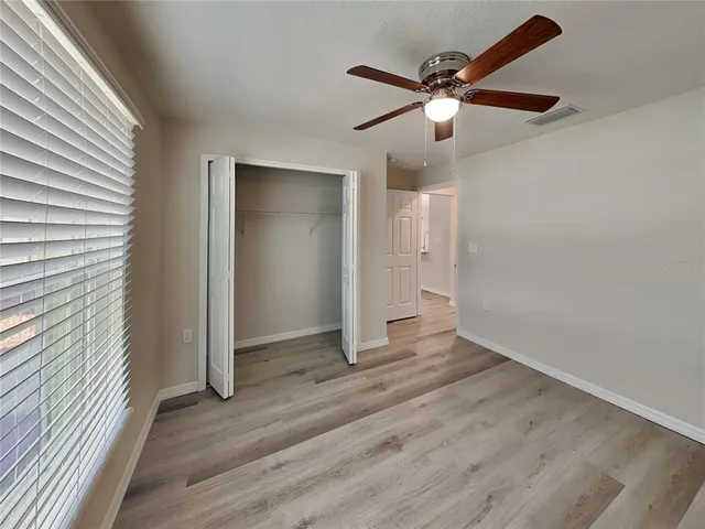 an empty room to hallway with wooden floor