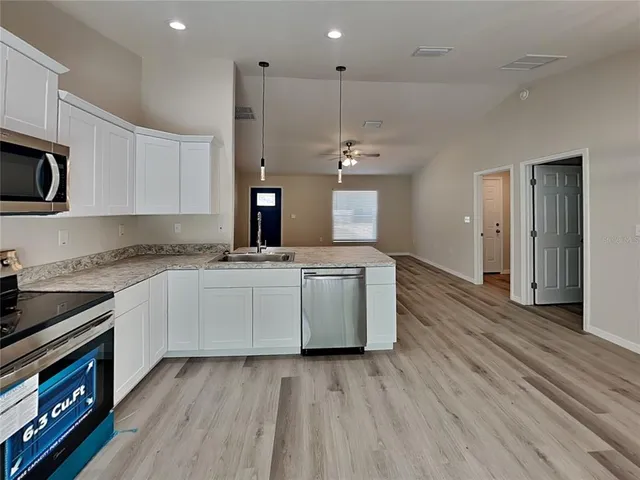 a kitchen with stove a sink and a refrigerator