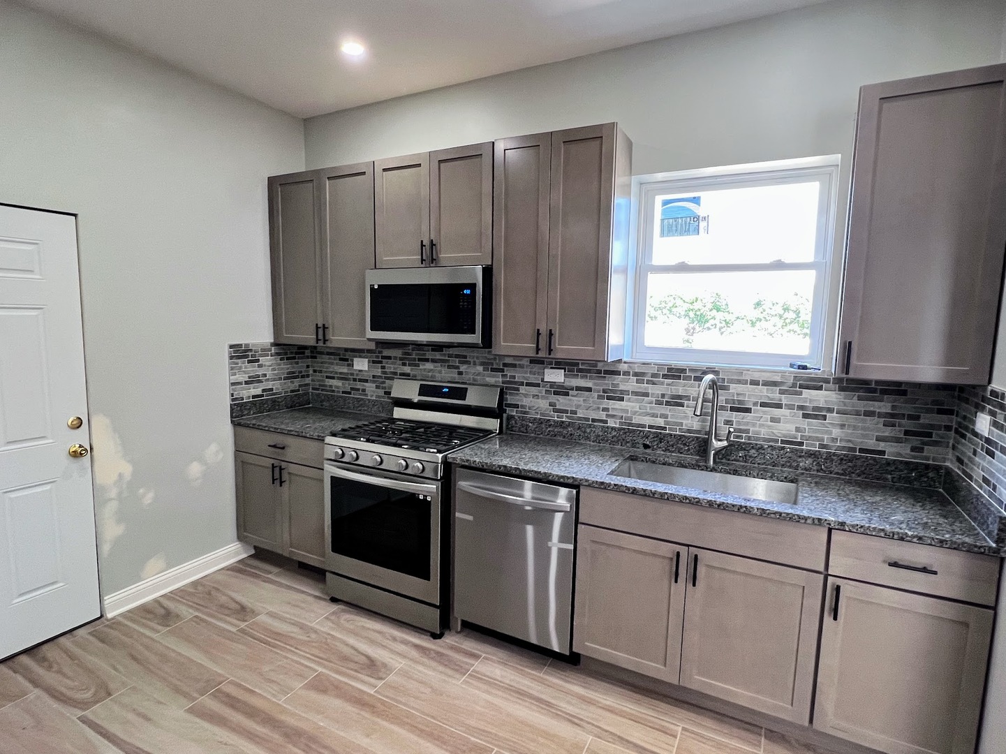 4244 North Spaulding Avenue, Unit 3 Chicago, IL 60618 - Photo 3 of 16 a kitchen with stainless steel appliances granite countertop a stove a sink and a microwave