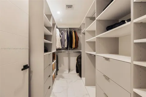 a view of walk in closet with clothes and shoes