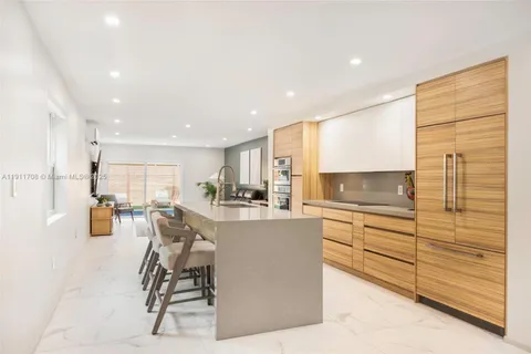 a kitchen with stainless steel appliances kitchen island granite countertop a refrigerator and cabinets
