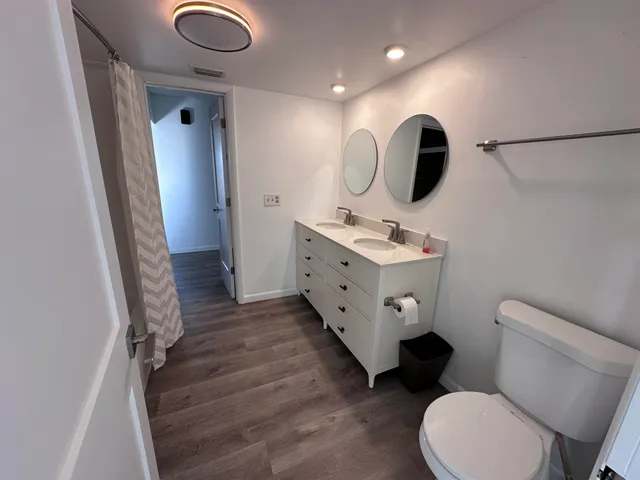 a bathroom with a toilet sink a mirror and vanity