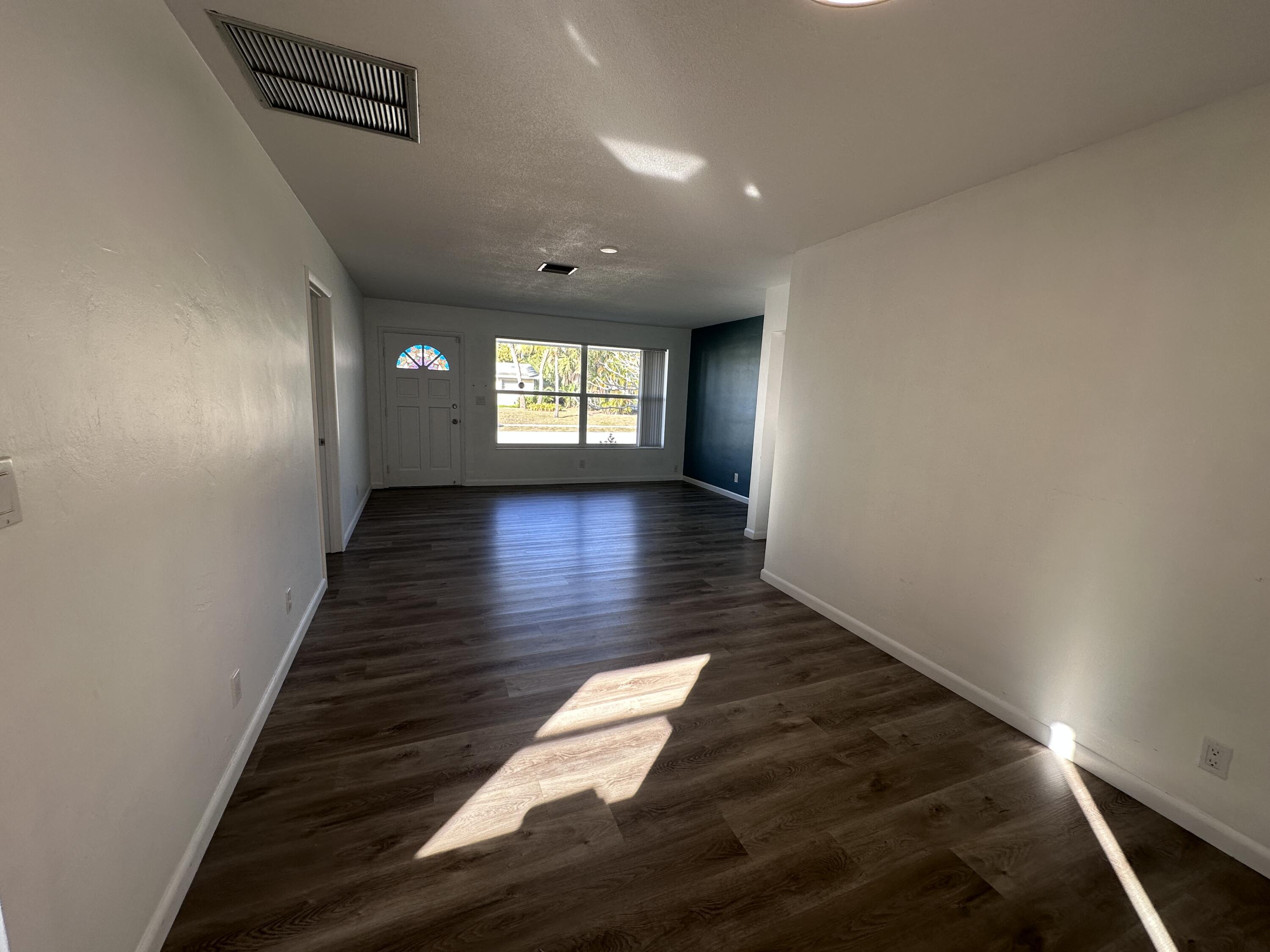 14 Ridgewood Circle Tequesta, FL 33469 - Photo 4 of 24 an empty room with wooden floor and windows