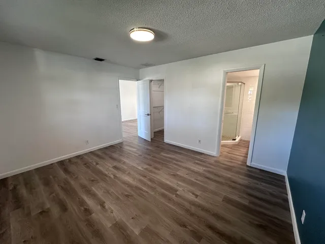 an empty room with wooden floor and closet