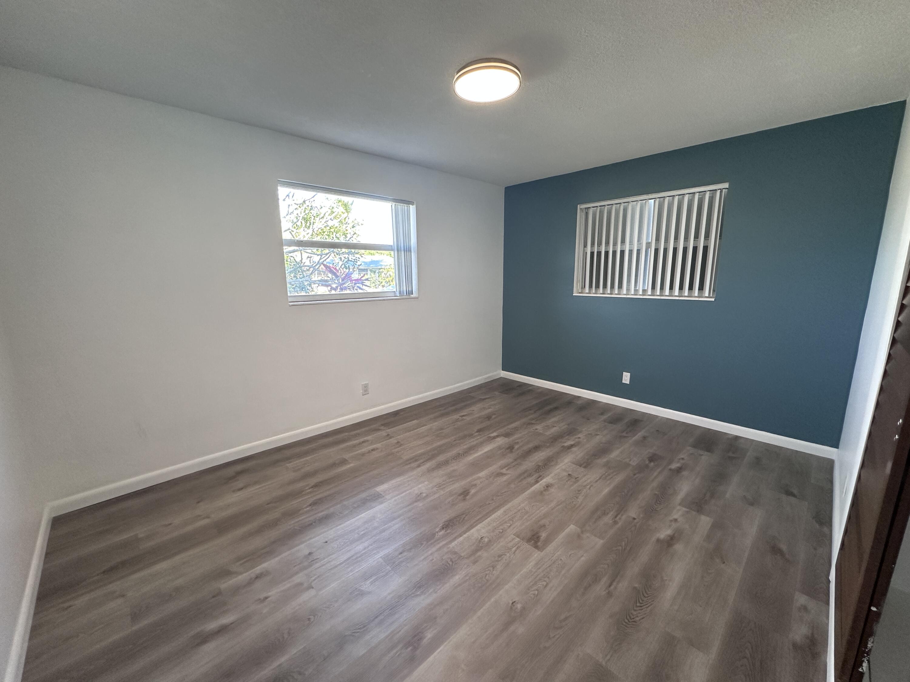 14 Ridgewood Circle Tequesta, FL 33469 - Photo 10 of 24 an empty room with wooden floor and windows