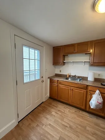 a kitchen with granite countertop a sink cabinets and wooden floor