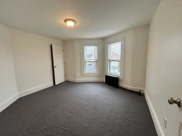 an empty room with windows and closet