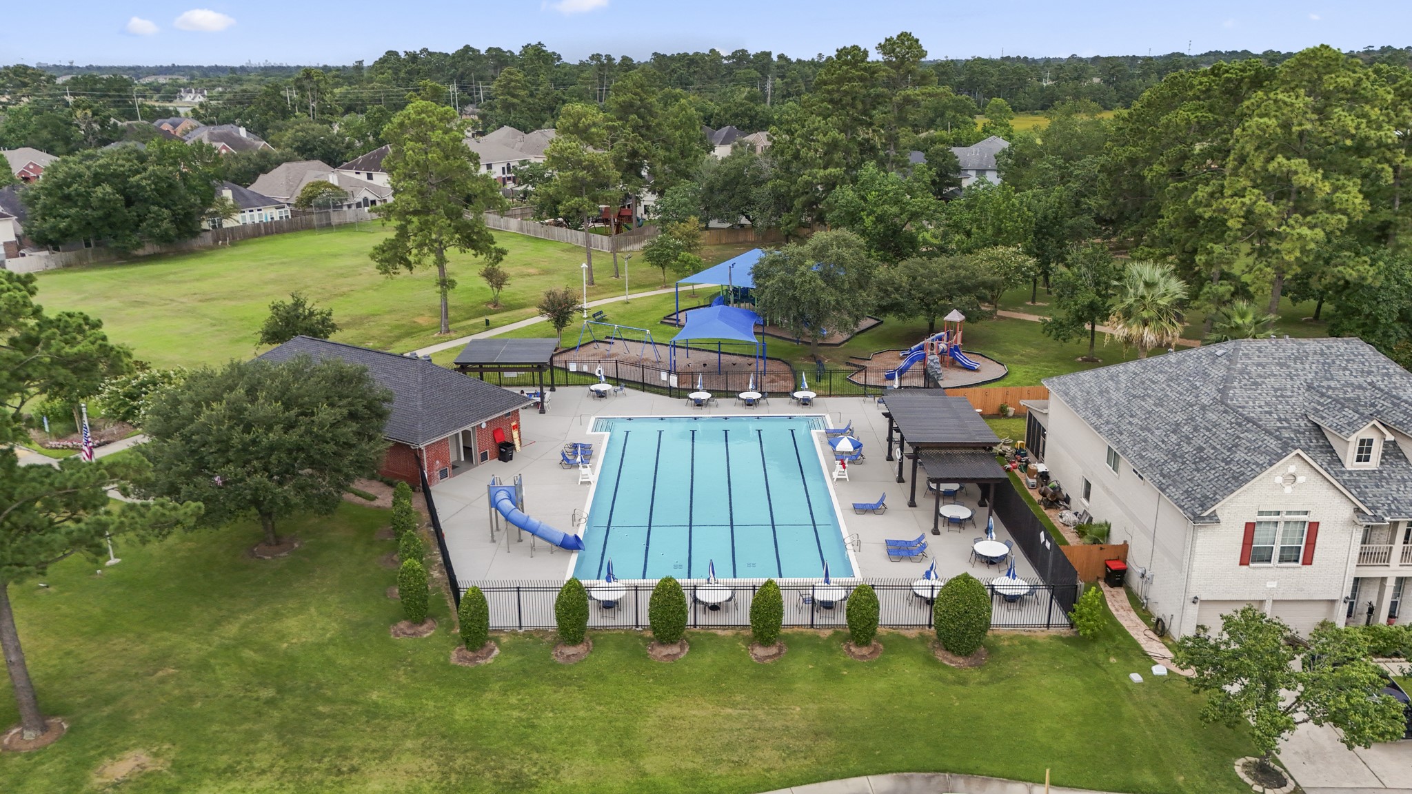 3411 Utah Beach Court Spring, TX 77388 - Photo 45 of 50 Pool days are part of the neighborhood lifestyle here, with Normandy Forest’s community pool, waterslide, clubhouse, and nearby green space adding to the everyday appeal. This view highlights one of the amenities just beyond 3411 Utah Beach Court, with parks, walking trails, and Historic Old Town Spring all close by.