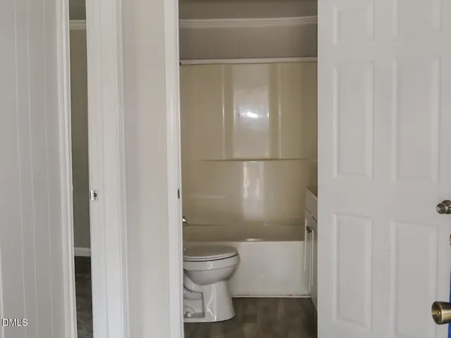 a bathroom with a granite countertop toilet and a sink