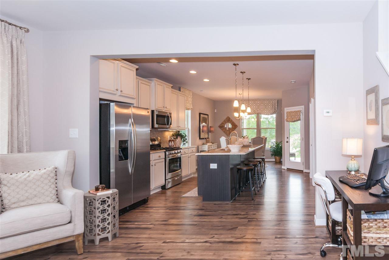 1116 Midtowne Way Durham, NC 27713 - Photo 19 of 25 a dining hall with stainless steel appliances granite countertop a refrigerator a sink dishwasher a dining table and chairs with wooden floor