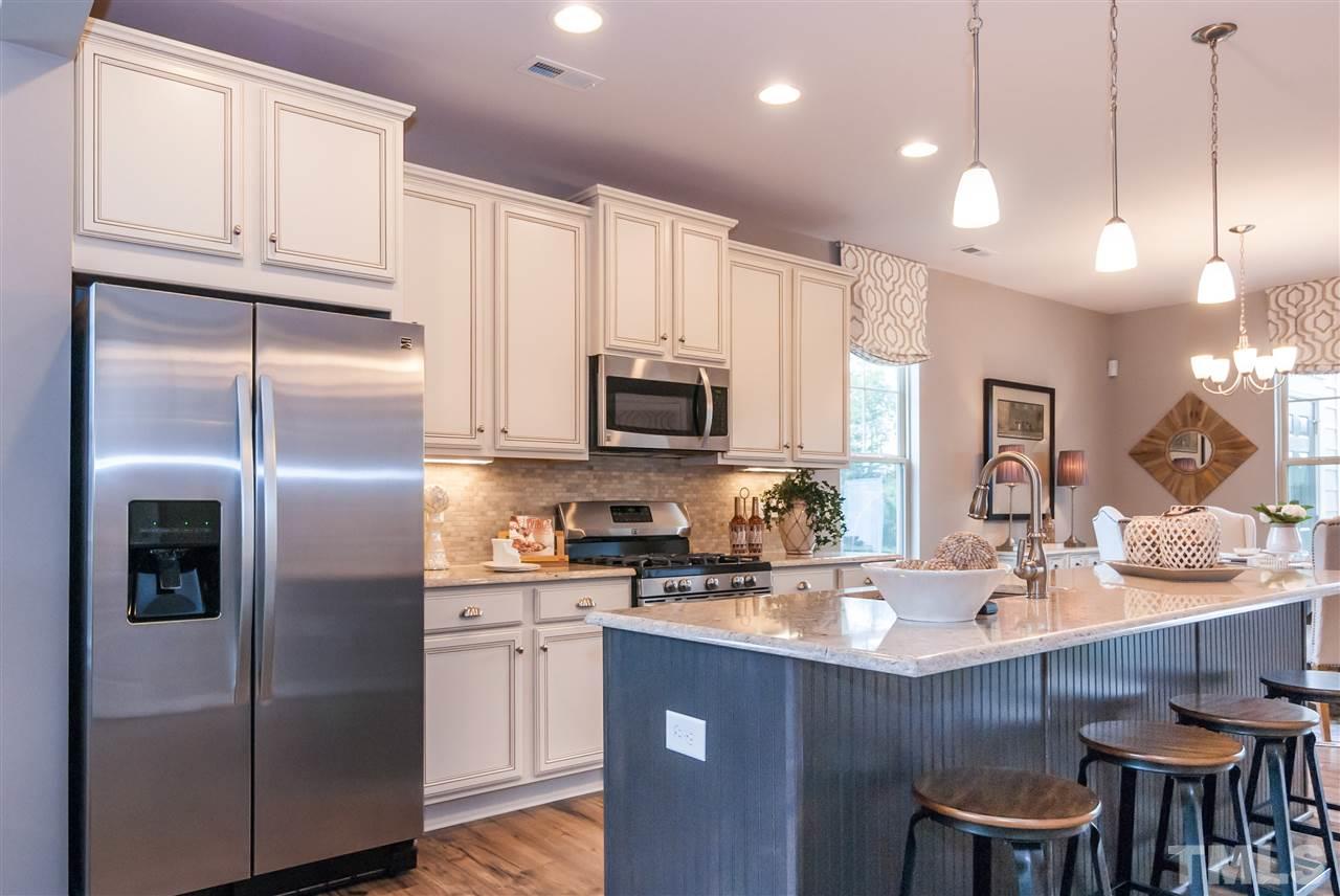 1116 Midtowne Way Durham, NC 27713 - Photo 22 of 25 a kitchen with stainless steel appliances granite countertop a refrigerator a sink a stove a dining table and chairs