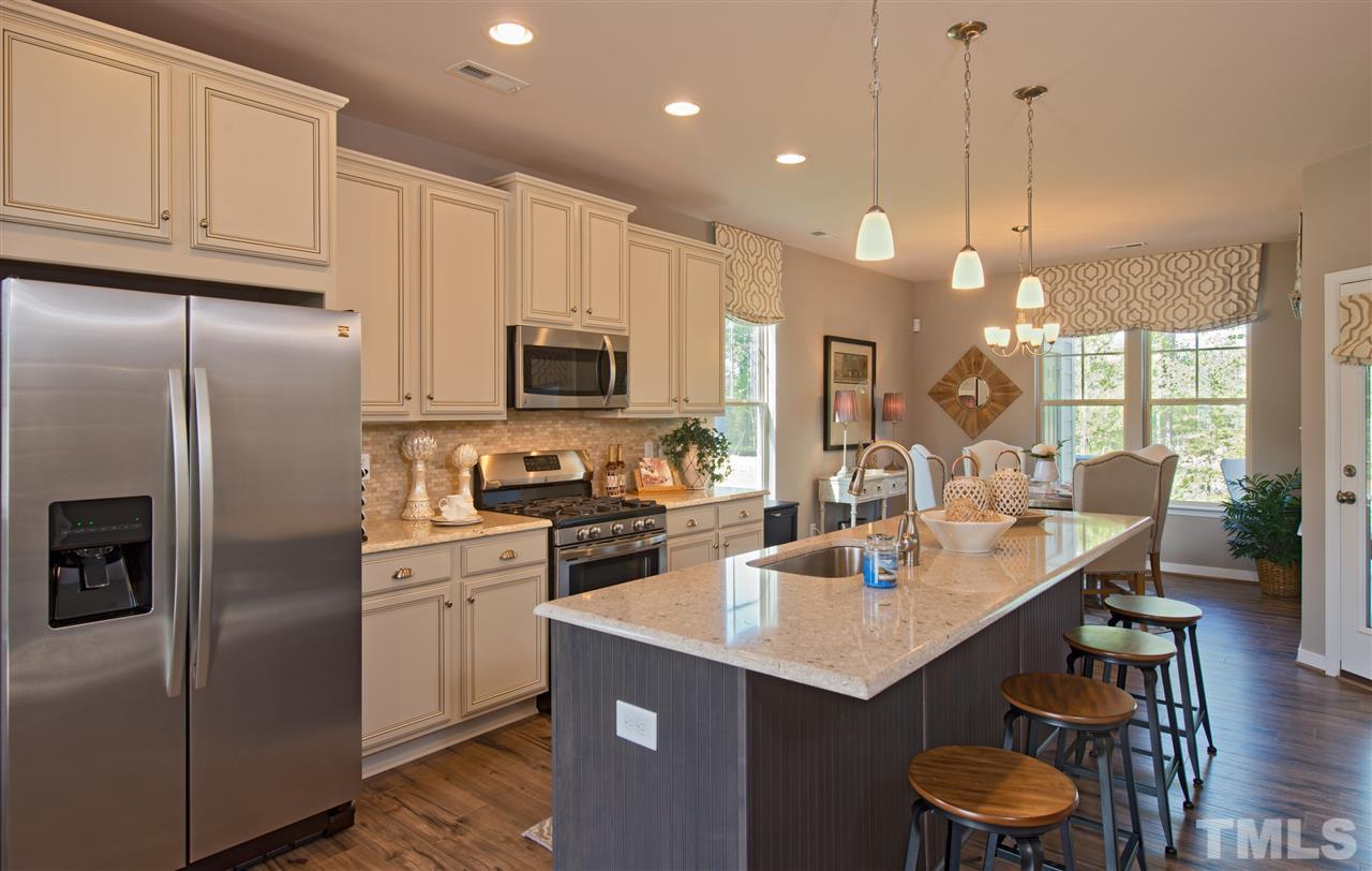 1116 Midtowne Way Durham, NC 27713 - Photo 7 of 25 a kitchen with kitchen island granite countertop a sink a center island and stainless steel appliances