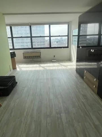 an empty room with wooden floor and a window
